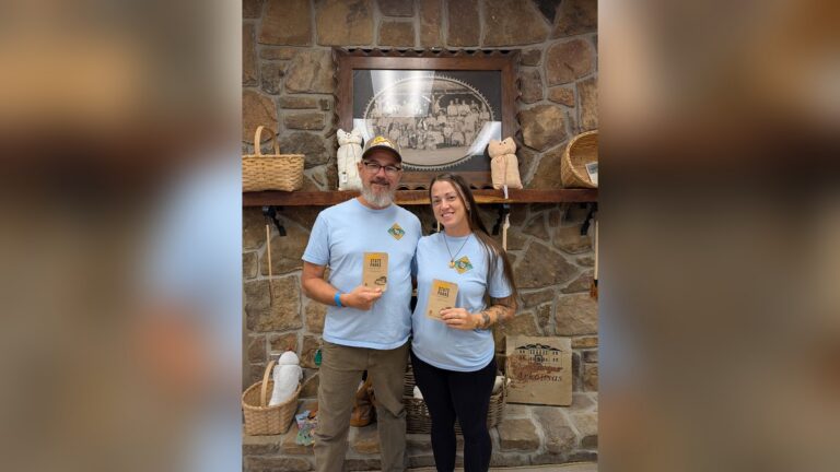 Steve Campbell and Erin Baber of Hot Springs hold their completed Arkansas State Parks Passports at the Ozark Folk Center