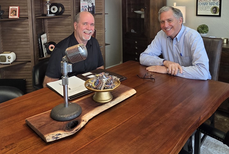 aCongressman French Hill and Bob Connell seated at a studio table with a vintage microphone during their Open Mic interview about Arkansas gas prices