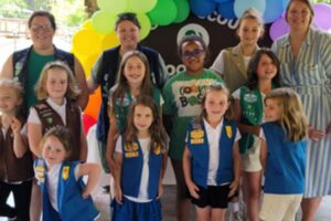 Girl Scouts and troop leaders from Girl Scouts Diamonds pose in front of balloons