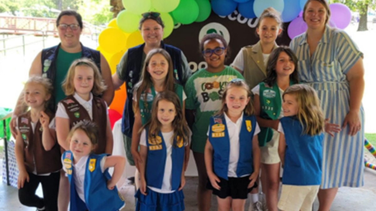 Girl Scouts and troop leaders from Girl Scouts Diamonds pose in front of balloons