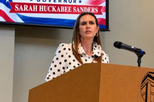Arkansas Governor Sarah Huckabee Sanders speaks at a Harding University podium during the Star Spangled 250th Birthday Bash in Searcy