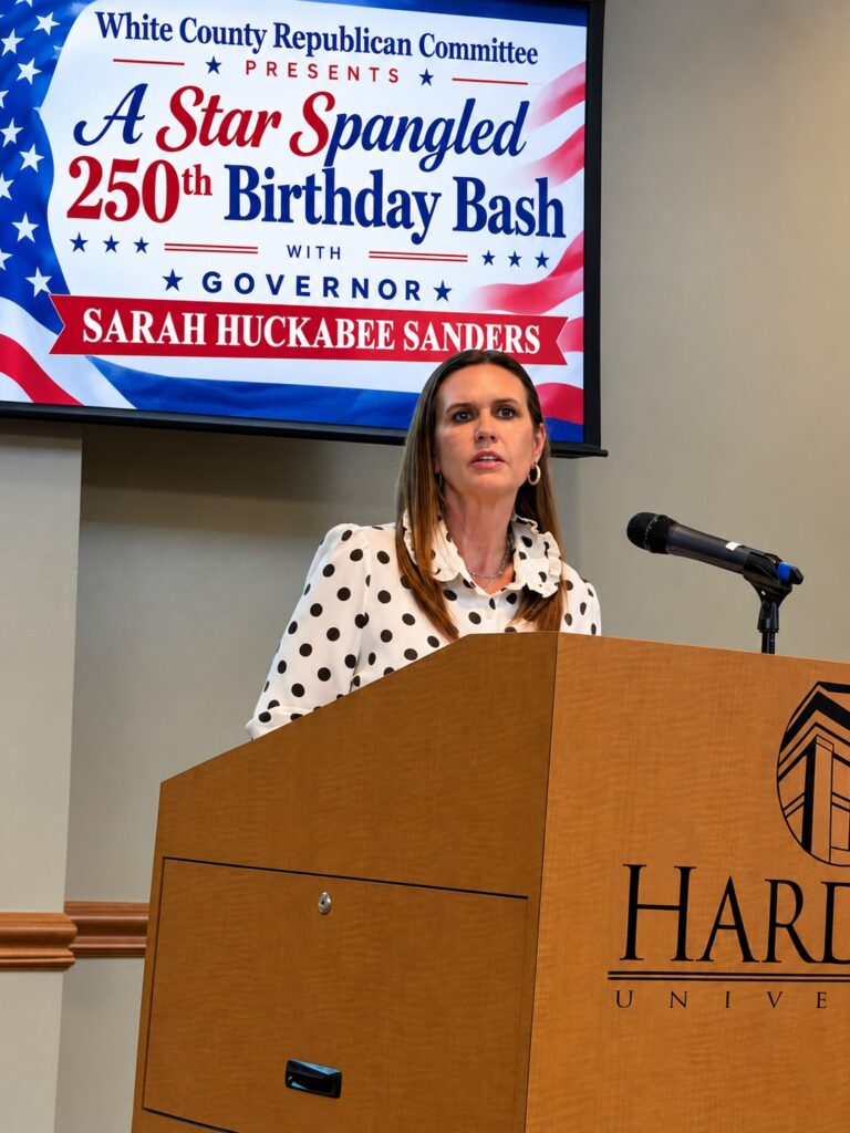 Arkansas Governor Sarah Huckabee Sanders speaks at a Harding University podium during the Star Spangled 250th Birthday Bash in Searcy